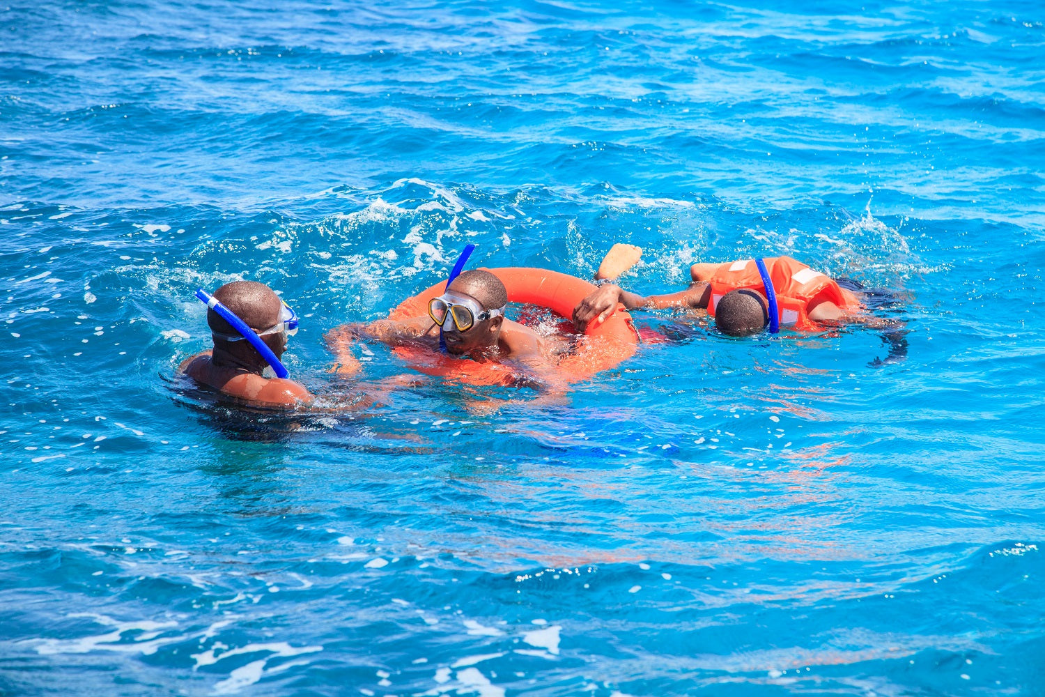 Four people snorkeling in clear blue water